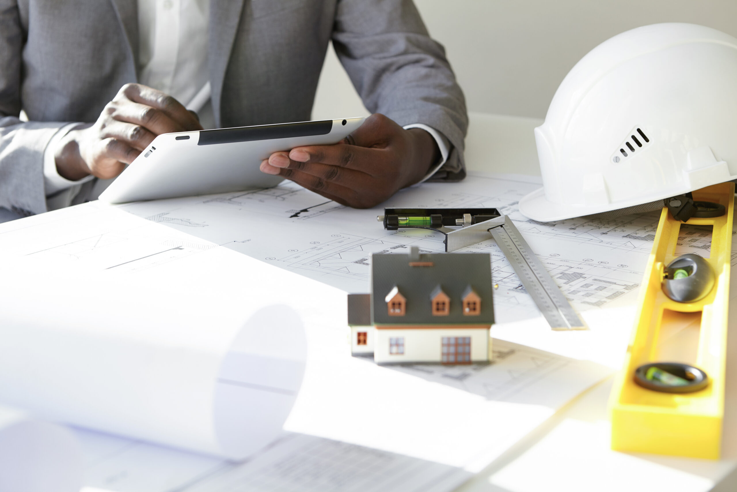 Conseiller immobilier étudiant un projet de construction avec plans et maquette